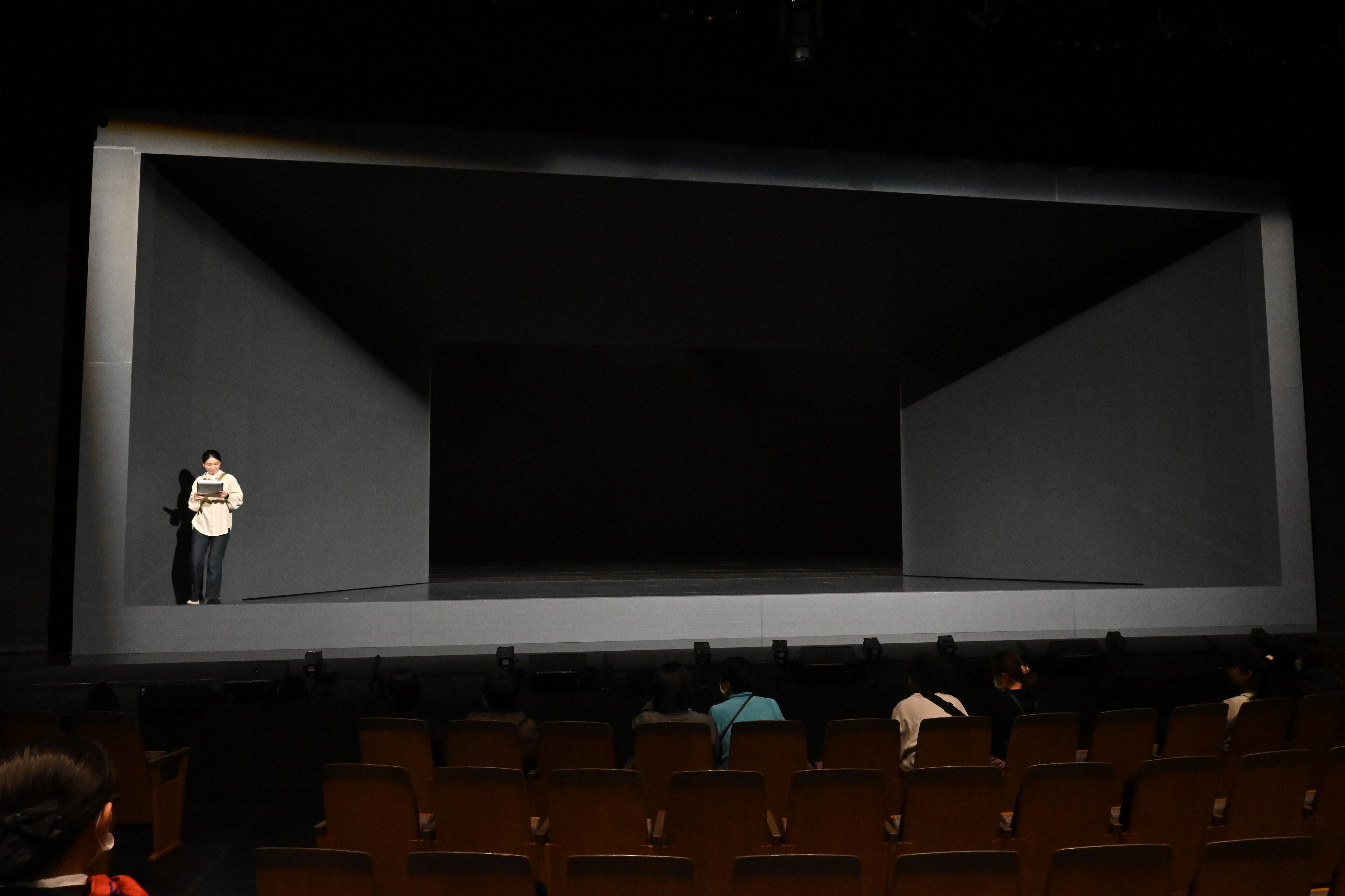 スタッフが舞台美術の上階部分の説明をしている写真