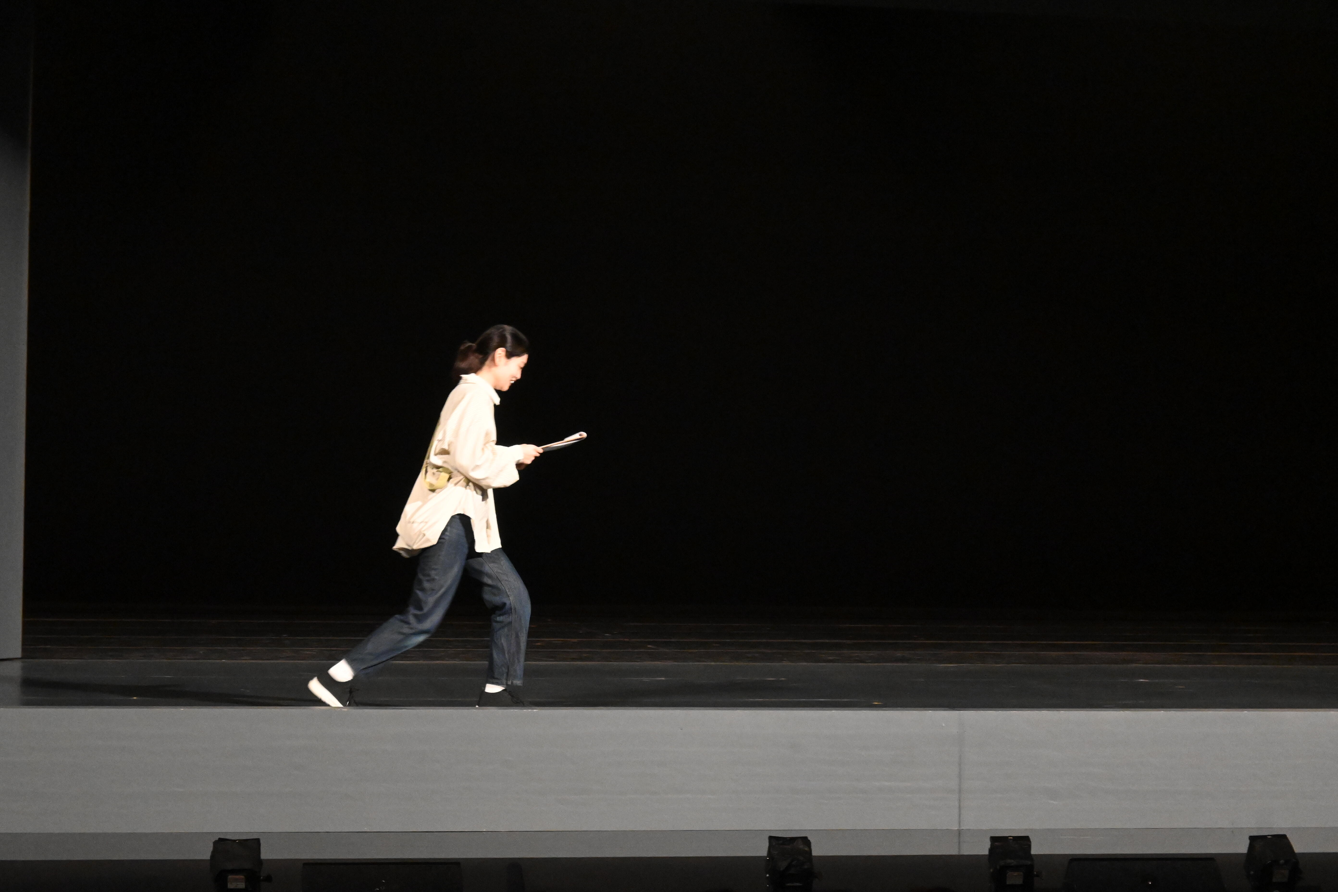 スタッフが舞台美術の上階部分の説明をしている写真